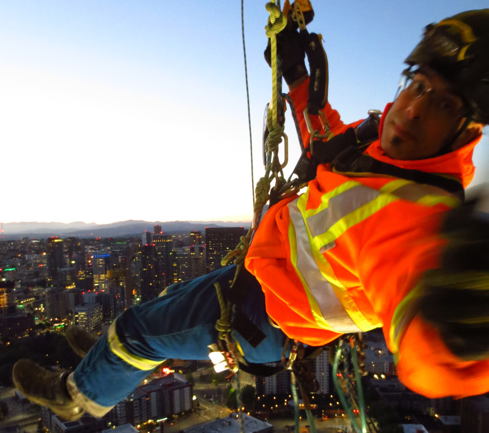Andrew hanging on ropes below Seattle's iconic Space Needle.