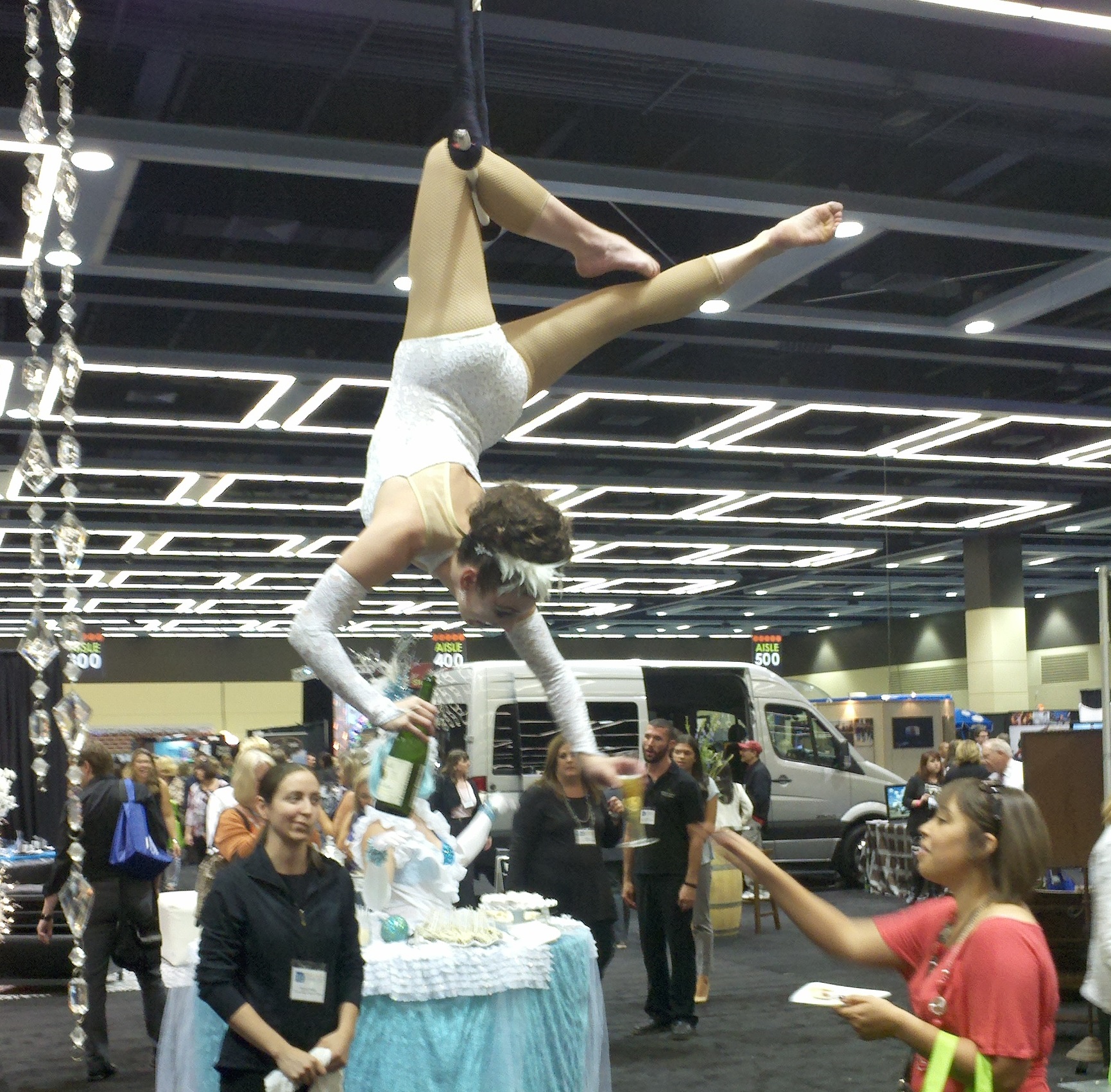 Trapeze acrobat serving champagne at a Pacific Northwest tradeshow.